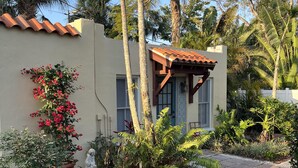 A garden with a paved walkway, a variety of plants, and a small statue. - TOP FLORIDA's La Casita (Fort Myers)