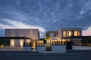 Un edificio moderno de dos pisos con techo plano, ventanas amplias y diseño minimalista.