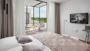 A modern hotel room with a large bed, a balcony with a view, and a flat-screen TV on the wall. - Luxury 5-Star Spa Villa for Up to 12 Guests (Bale)