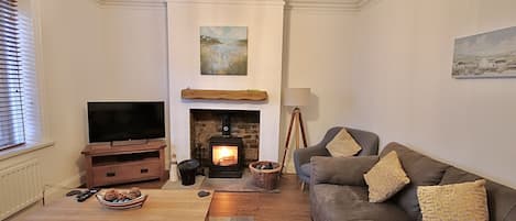 A living room with a fireplace, a television, and a sofa.