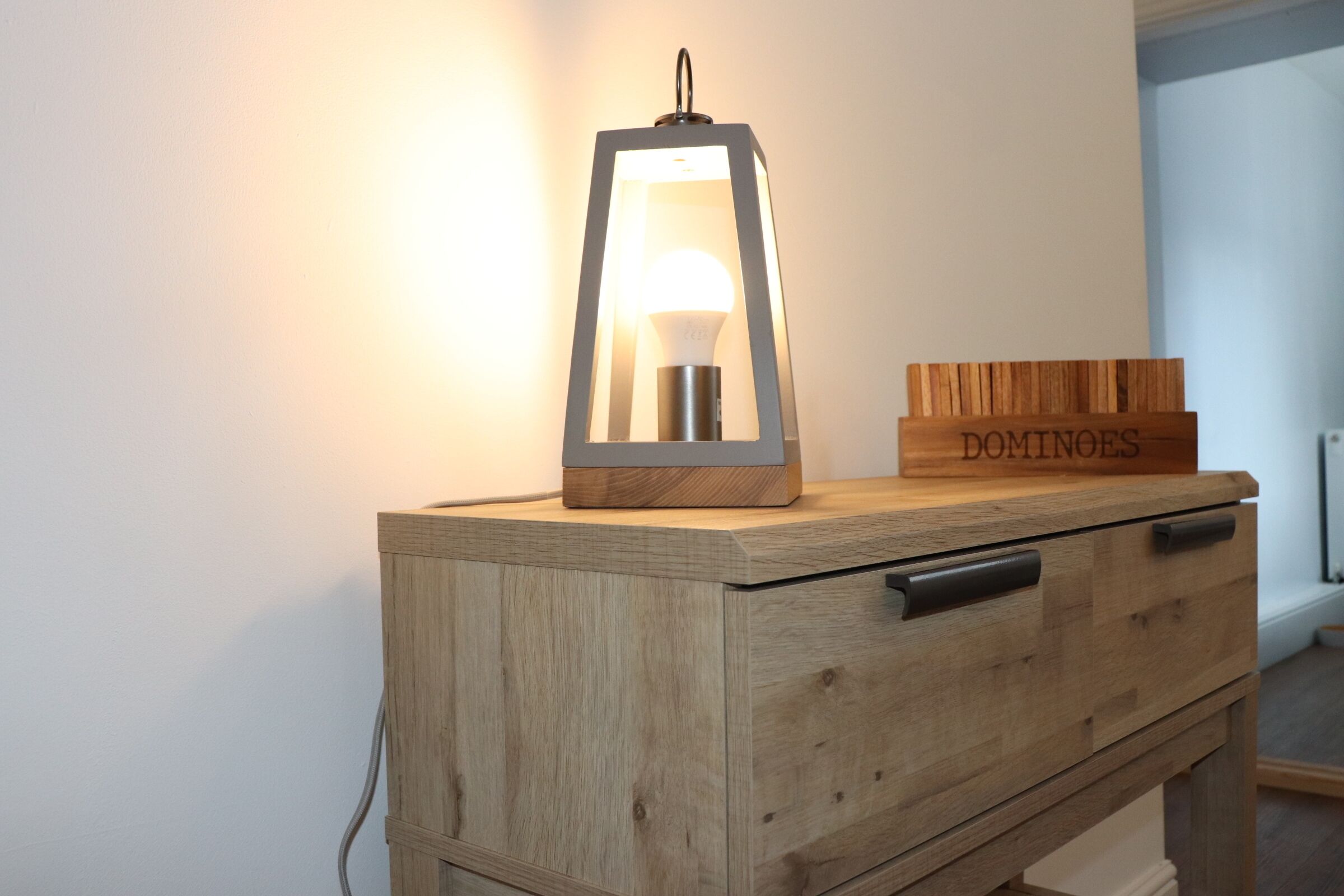A wooden cabinet with drawers and a hanging light fixture.