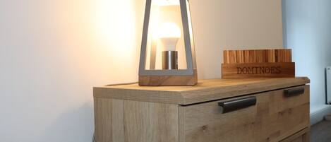 A wooden cabinet with drawers and a hanging light fixture.