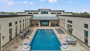 Ein modernes Gebäude mit Pool, Außenbereich und einer überdachten Terrasse.
