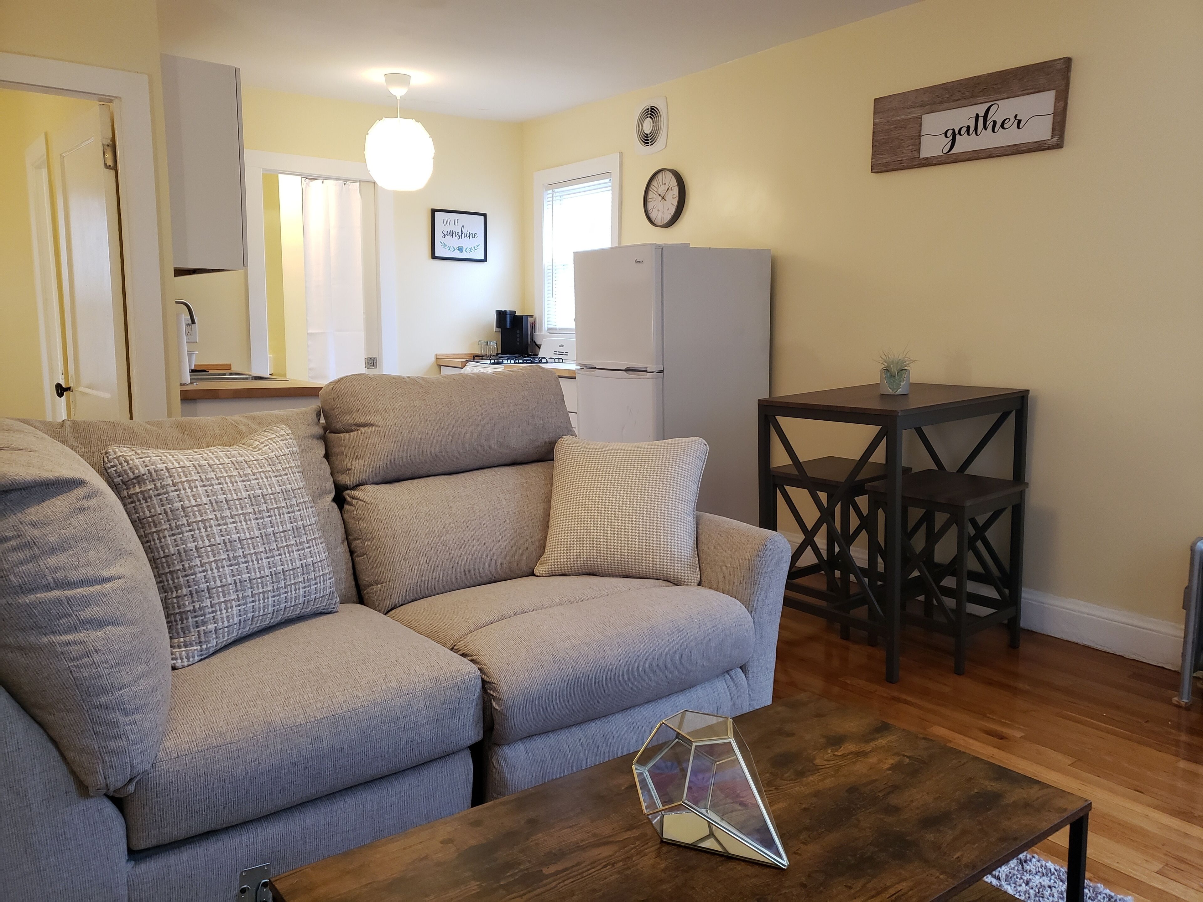 Un salon comprenant un canapé, une table basse et un coin repas avec une table et des chaises.