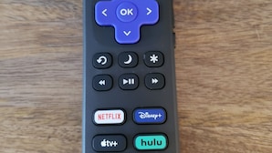 Un control remoto con botones direccionales, un botón de encendido y botones para Netflix, Disney+, Apple TV+, Hulu y Roku TV.