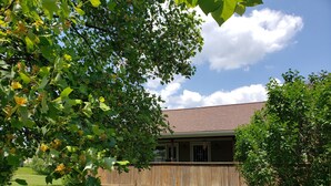A house with a wooden deck and a lawn. - Conveniently located 2 bedroom home only minutes from hiking and state park fun! (Warren)