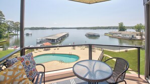 A balcony with a pool, chairs, and a table overlooking a lake with docks and boats. - Sweet Lake Get Away (#2) in the Heart of Hot Springs (Hot Springs)