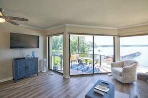 Relax in this spacious living area with a flat-screen TV, armchair, and patio access.