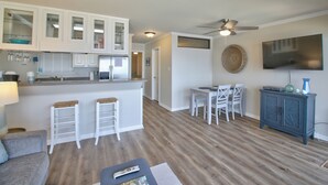 A modern kitchen with white cabinets, a bar area, and a dining space with white chairs. - Sweet Lake Get Away (#2) in the Heart of Hot Springs (Hot Springs)