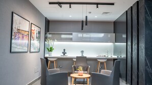 A modern kitchen with a central island, pendant lighting, and a dining area with two chairs. - Liv weibdeh (Amman)