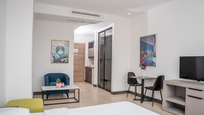 A modern hotel room with a bed, a desk, a chair, a TV, and a painting. - Liv weibdeh (Amman)