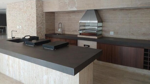 Een moderne keuken met een groot eiland, een ingebouwde oven en een strakke spatwand.