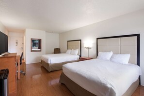 A hotel room with two beds, a desk, a chair, a television, and a mirror. - Americas Best Value Inn Lockhart (Lockhart)