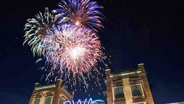 A hotel with a prominent sign and a view of fireworks in the night sky. - Quaint Cottage by the Bay - Boat Launch 1 Street Over (Elberta)