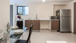 A modern kitchen with a dining area, stainless steel appliances, and a window providing natural light. - Comfortable and reliable stay, convenient location (Mexico City)