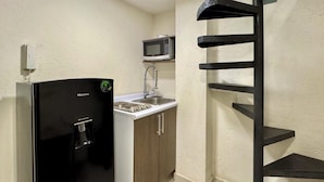 A compact kitchen with a black refrigerator, a microwave, and a sink. - Reliable Double-Height Stay. Great CDMX Location (Mexico City)