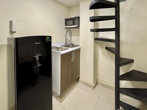 Een koelkast, een magnetron, kookgerei, borden en bestek