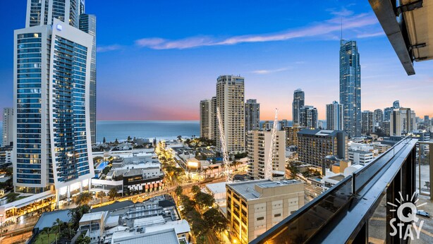 A cityscape with high-rise buildings, a waterfront, and a modern bridge.