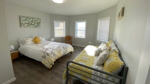A bedroom with two beds, a chair, and a ceiling light. - Charming 4bedroom 2nd Floor Beach House - 1.5 blocks to the beach (Long Branch)