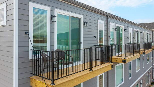 A multi-story building with balconies, each featuring a wooden deck and black metal railings. - New - Lookout Views 2 Br/2BA Sleeps 8 next to OddStory Brewery! Pet friendly! (Chattanooga)