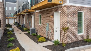 A row of brick townhouses with balconies, outdoor air conditioning units, and a pathway. - New - Lookout Views 2 Br/2BA Sleeps 8 next to OddStory Brewery! Pet friendly! (Chattanooga)