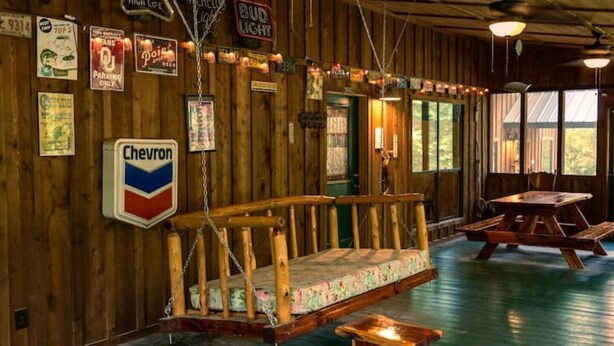 Un intérieur en bois avec un banc, des tables et un panneau en forme de chevron.