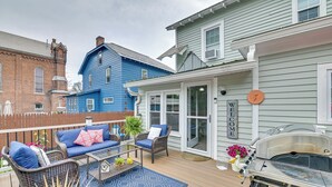 Una terraza con mobiliario exterior, una parrilla y un letrero que dice 'WELCOME'.