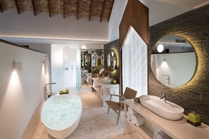 A modern bathroom with a freestanding bathtub, a large mirror, and a vanity with a sink.
