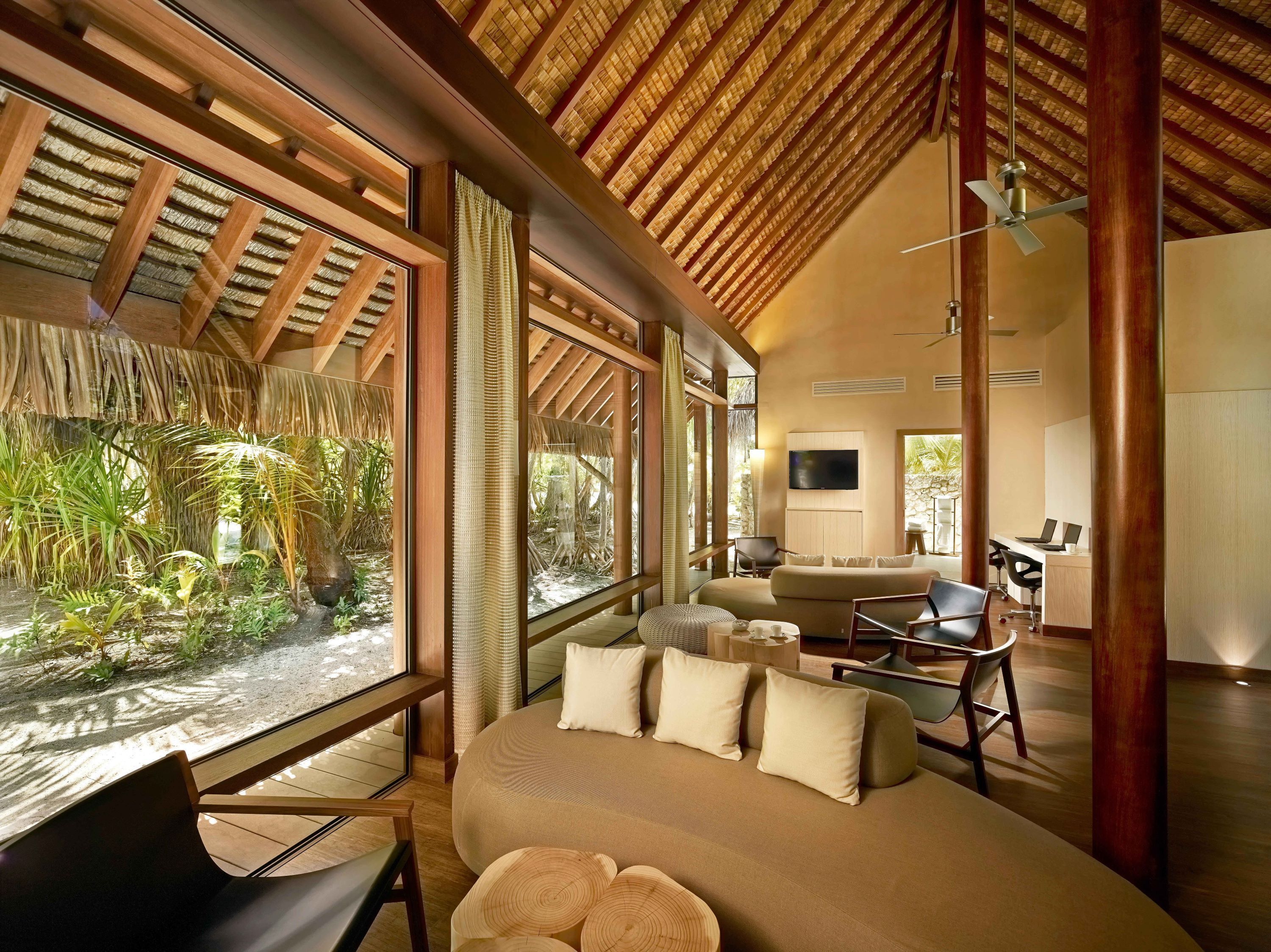 A modern interior with a large bed, seating area, and a TV.