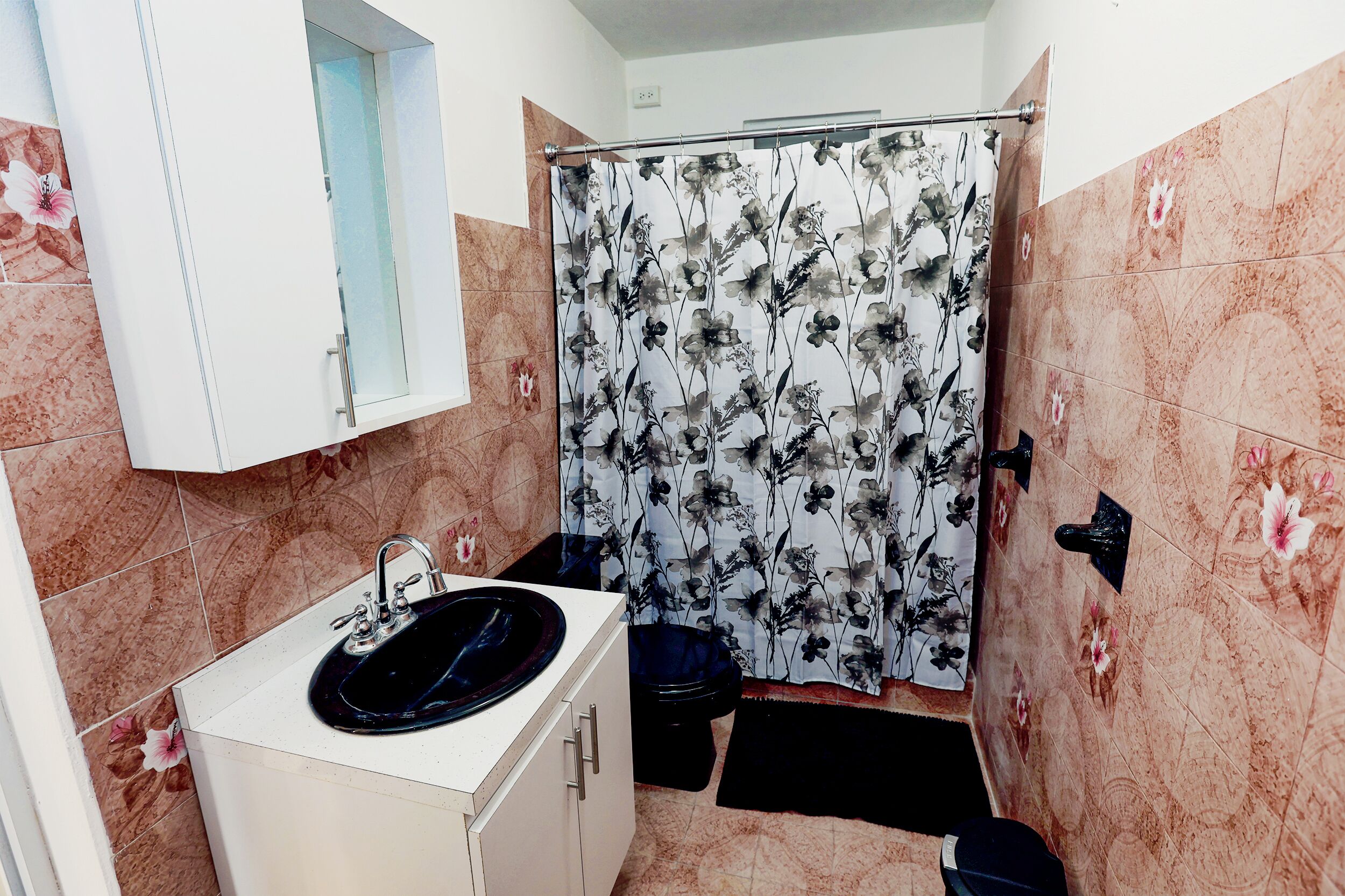 Ein Badezimmer mit Waschbecken, Toilette und Duschvorhang.