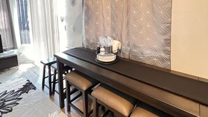 A dining area with a long table, benches, and a hanging light fixture.