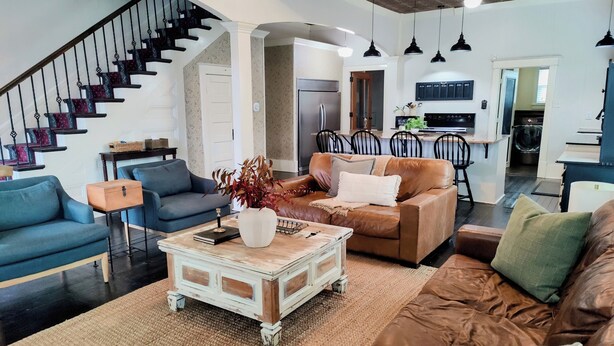 A spacious living room with a staircase, a dining area, and a kitchen. - The Conner House-Walk to Magnolia! (Waco)