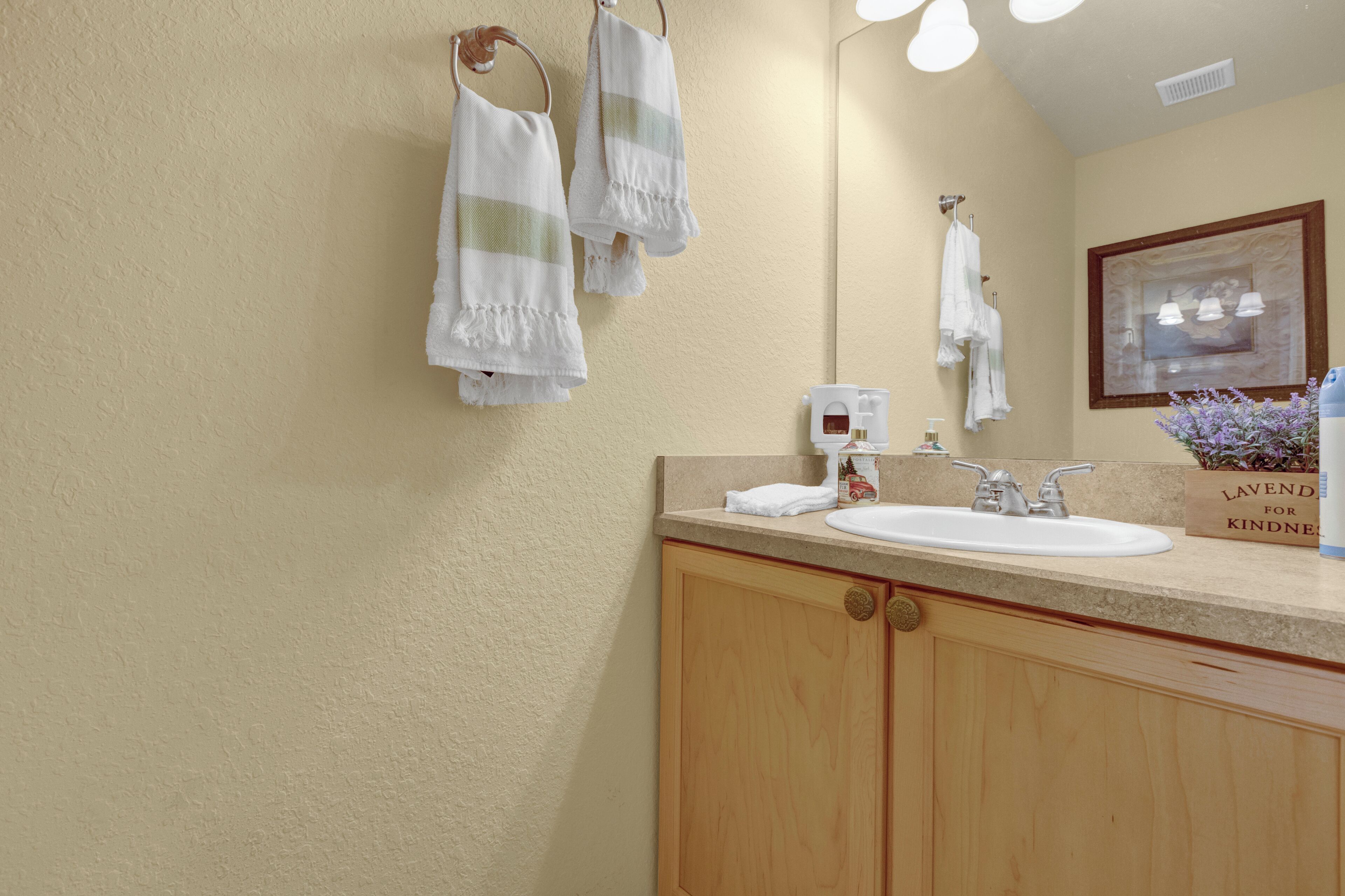Un baño con lavamanos, toallero y espejo.