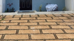 Un immeuble de deux étages avec une porte noire, un balcon et le numéro « 29 » peint sur le mur.