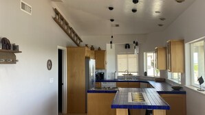 A spacious kitchen with wooden cabinets, a central island, and a view to the outside. - Colorado River Retreat w/ RV spot  (Big River)