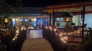 A pathway leading to a restaurant with string lights and a sign that reads "Smile you're on Camera." - Oceanfront Oasis;  Fun family retreat, with private pool, snorkeling steps away. (Christiansted)