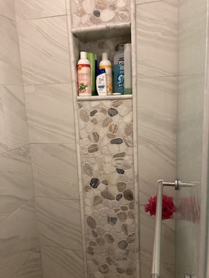 Een bad/douchecombinatie, een haardroger, handdoeken, zeep