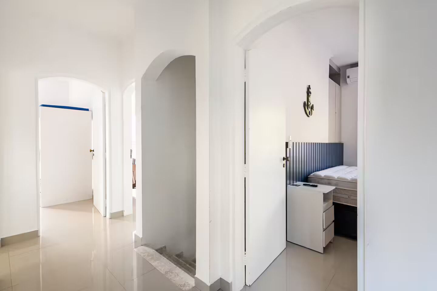 Una habitación de hotel moderna con una cama, mesita de noche y una obra de arte colgada en la pared.