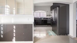 Een moderne keuken met een roestvrijstalen koelkast, een inbouwoven en een groot raam.