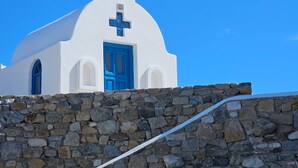 A white building with a blue door and a cross, set against a clear blue sky. - WhiteStone Villa Mykonos with private pool (mykonos)