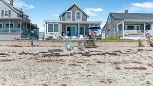 A beachfront property with a large house featuring a porch and multiple windows. - STUNNING BEACHSIDE HOME-WELLS BEACH: 180 DEGREE OCEAN VIEWS: 9-1 to 9-3 open (Wells)