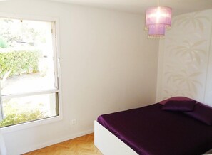 Cozy retreat with a bed and natural light, featuring a window and a pendant light.