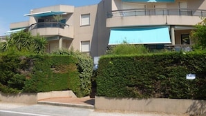 A modern multi-story building with balconies and a flat roof.