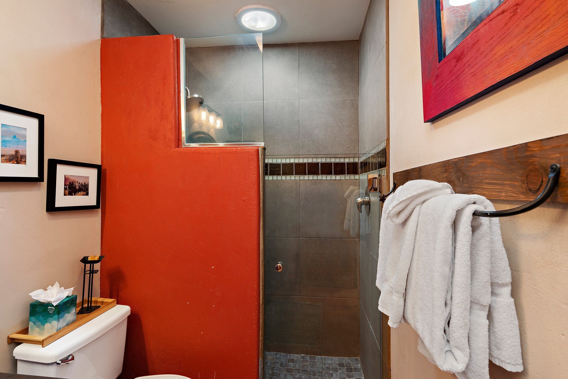 A bathroom with a toilet, a shower, and a towel rack.