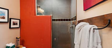 A bathroom with a toilet, a shower, and a towel rack.