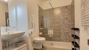 Un baño moderno con lavamanos, inodoro y zona de ducha.