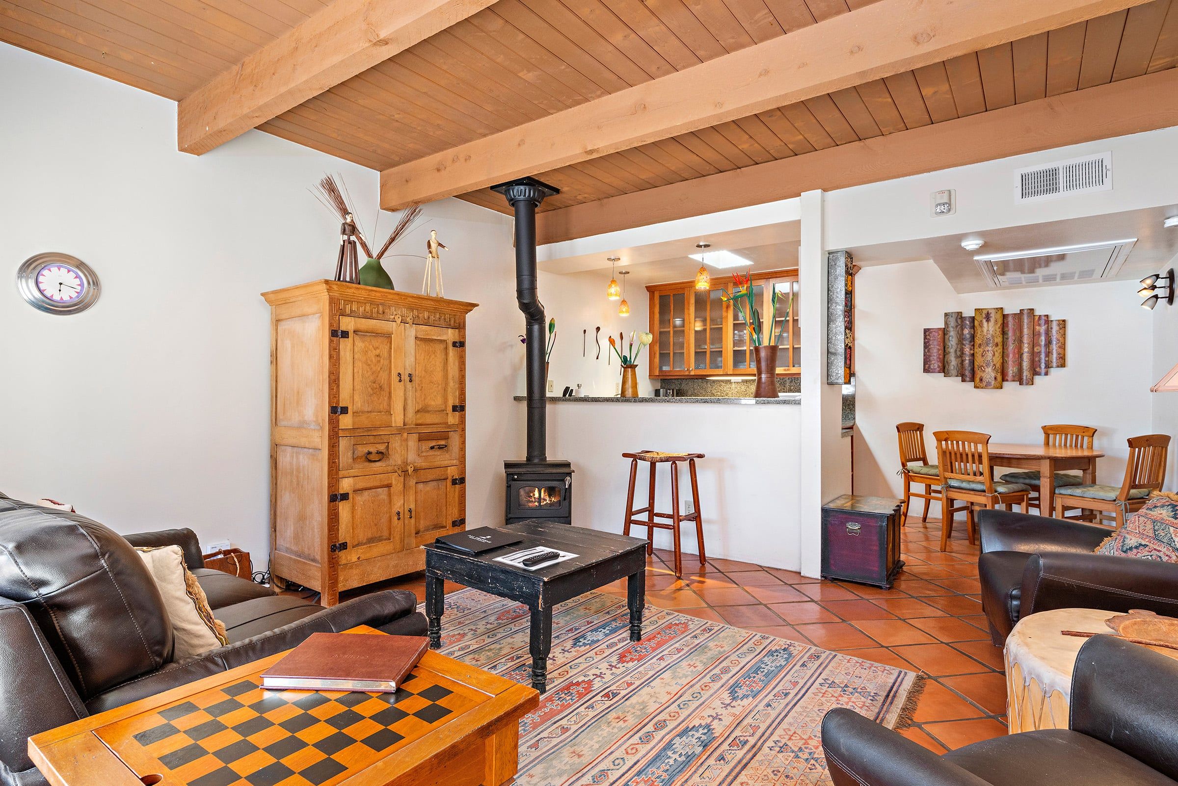 Un salon chaleureux avec une cheminée, un jeu d’échecs et un meuble en bois.