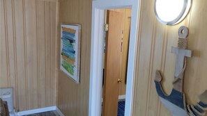 Stylish hallway with a door leading to another room, featuring a unique painting and a small light fixture.