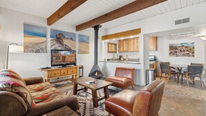 Ein Wohnzimmer mit Kamin, Holzmöbeln und Kunstwerken an den Wänden.