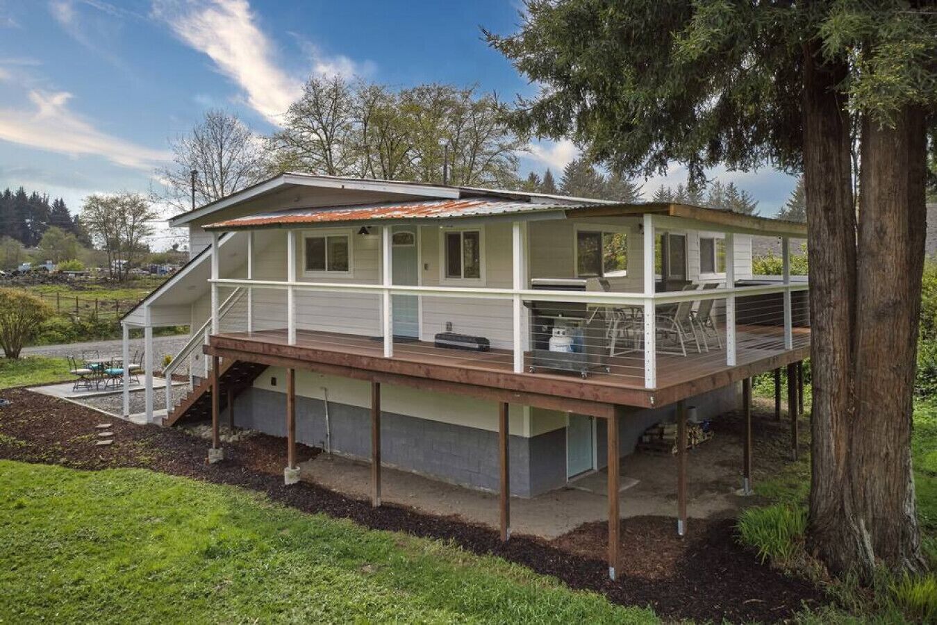 A two-story house with a wooden deck and a covered outdoor area.